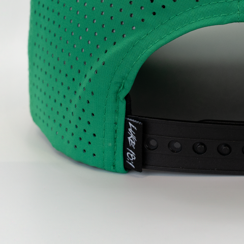 rear view of kelly green hat with black and white LUKE 18:1 label on back