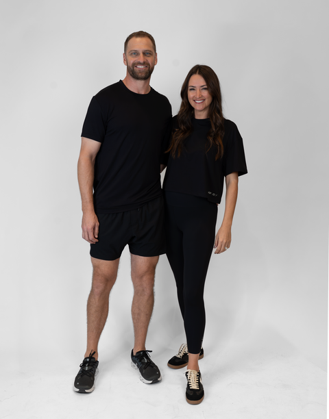 man and woman standing together with woman wearing ladies Bamboo Mid-Crop Tee with "Luke 18:1" text above bottom seam