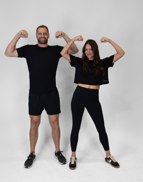 man and woman flexing with woman wearing black Ladies Performance Legging