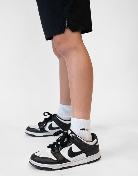 person wearing white socks with Luke 18:1 text in black