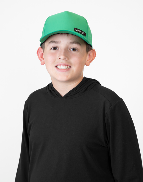 Child wearing kelly green hat with "LUKE 18:1" text