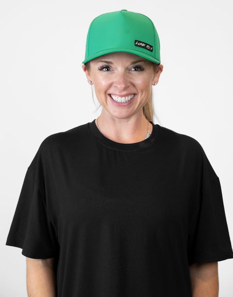 Woman wearing kelly green hat with "LUKE 18:1" text