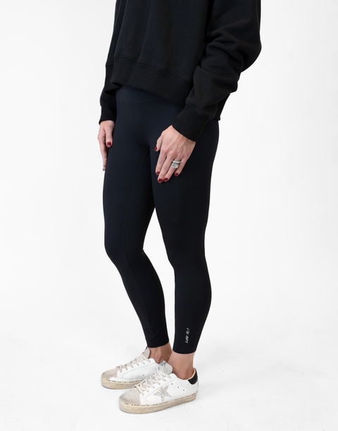 side view of person wearing black Ladies Performance Legging with "LUKE 18:1" text on ankle