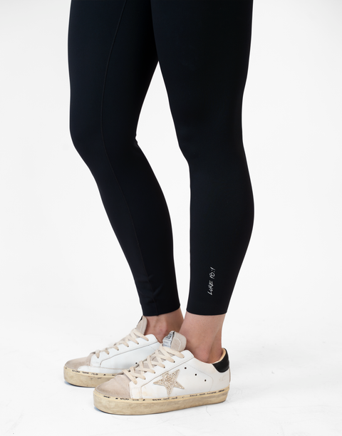 side view of person wearing black Ladies Performance Legging with "LUKE 18:1" text on ankle