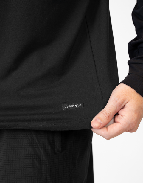 closeup of front of Man wearing Men's Black Bamboo Performance Hoodie showing "LUKE 18:1" text above bottom seam