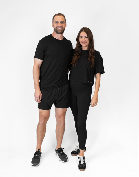 man and woman standing together with woman wearing ladies Bamboo Mid-Crop Tee with "Luke 18:1" text above bottom seam