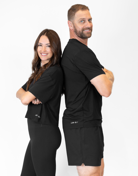 man and woman standing back to back with man wearing men's black 6" airflow shorts