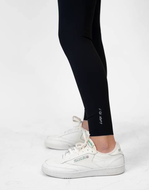 closeup of black Ladies Performance Legging with "LUKE 18:1" text on ankle
