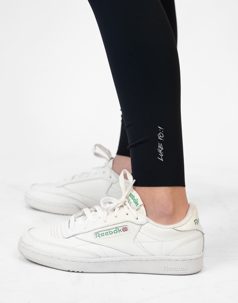 closeup of black Ladies Performance Legging with "LUKE 18:1" text on ankle