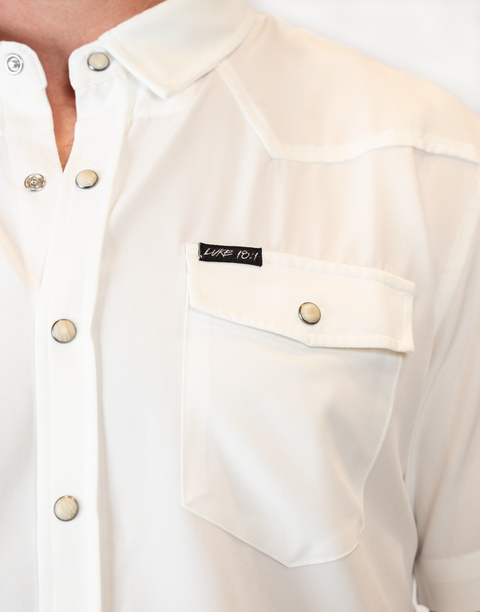 Man wearing Men's White S/S Pearl Snap Shirt showing "LUKE 18:1" text on pocket