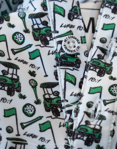 closeup of pattern of performance golf polo showing golf carts, flags, golf balls, tees, and "LUKE 18:1" text