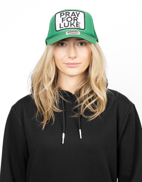 Person wearing a green cap with 'Pray for Luke' patch