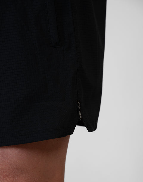side view of man wearing Men's Black 6" Airflow Short showing "LUKE 18:1" text on side seam