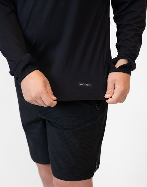 closeup of bottom front of Boy wearing Youth Black Bamboo Performance Hoodie showing "LUKE 18:1" text