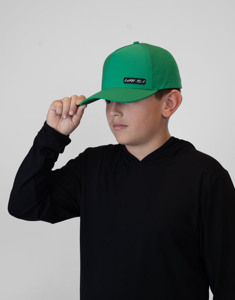 Child wearing kelly green hat with "LUKE 18:1" text