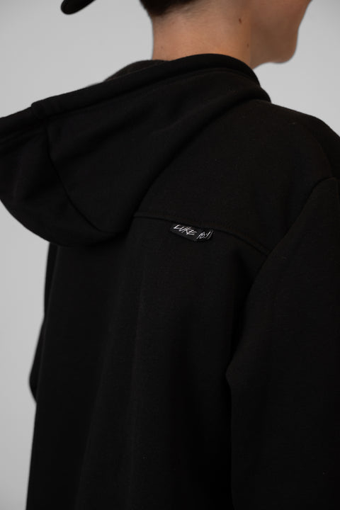 Rear view of boy wearing Youth Black Fleece Hoodie showing "LUKE 18:1" text on upper right back