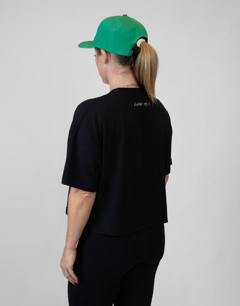 Rear view of woman wearing ladies Bamboo Mid-Crop Tee with "Luke 18:1" text on upper back