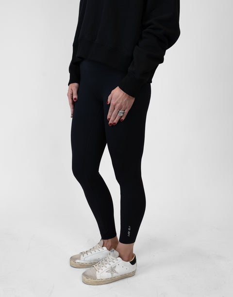 side view of person wearing black Ladies Performance Legging with "LUKE 18:1" text on ankle