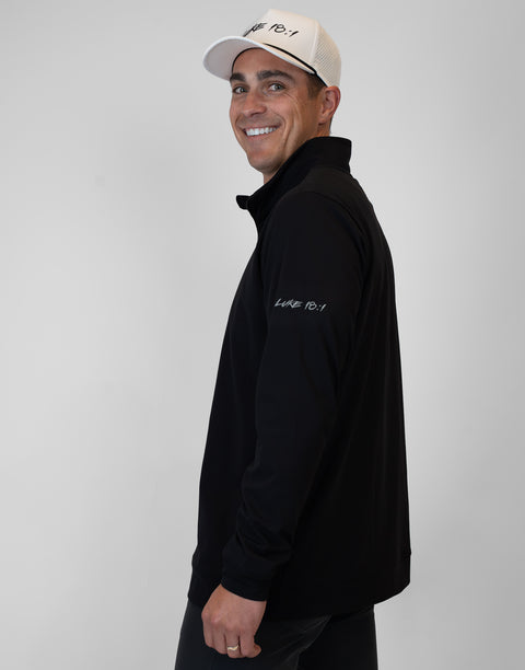 side view of Man wearing Men's black Performance 1/4-Zip with "LUKE 18:1" text on sleeve