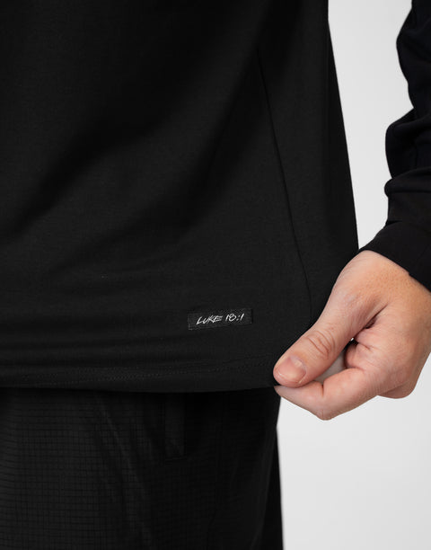 closeup of front of Man wearing Men's Black Bamboo Performance Hoodie showing "LUKE 18:1" text above bottom seam