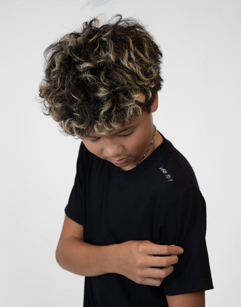 Boy wearing Youth black Bamboo Performance Tee with "LUKE 18:1" text on shoulder