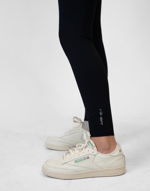 closeup of black Ladies Performance Legging with "LUKE 18:1" text on ankle