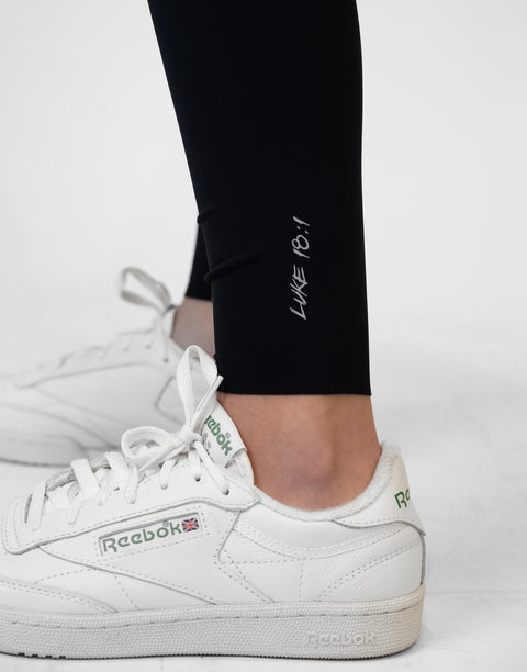 closeup of black Ladies Performance Legging with "LUKE 18:1" text on ankle