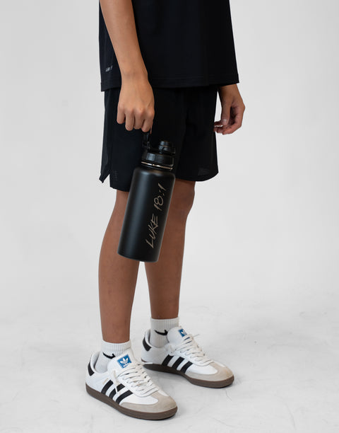 Person holding a black water bottle with 'Luke 18:1' text on a white background