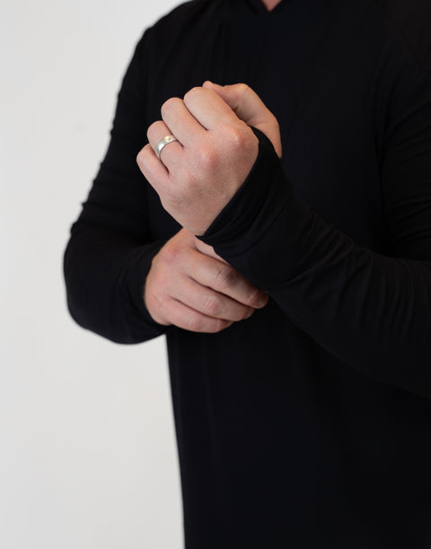 Closeup of man wearing Men's Black Bamboo Performance Hoodie showing thumb holes