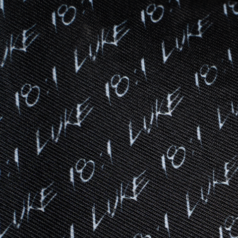 closeup of black and white "LUKE 18:1" pattern on underside of brim of straw hat