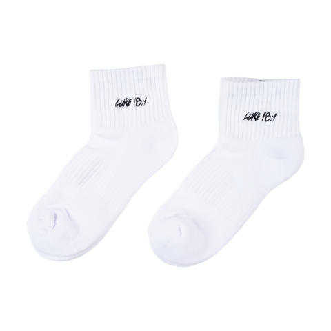 White socks with black "LUKE 18:1" text on ankle