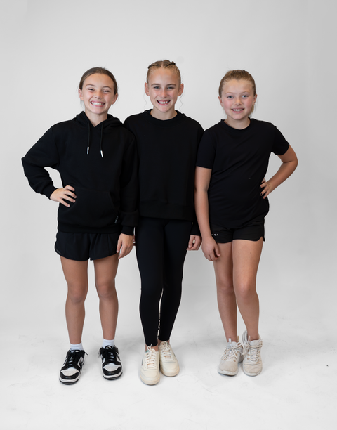 group of 3 girls with 2 wearing girls black flowy performance short with "LUKE 18:1" text