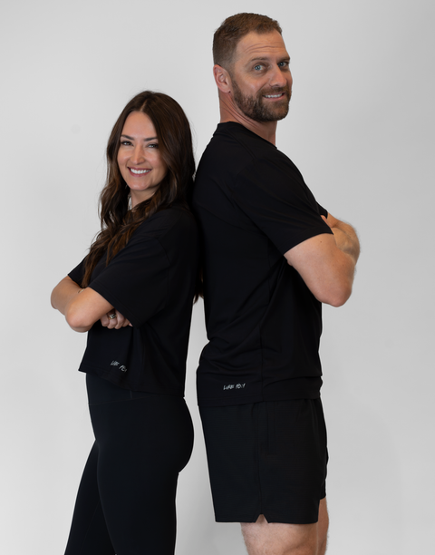man and woman standing together with woman wearing ladies Bamboo Mid-Crop Tee with "Luke 18:1" text above bottom seam