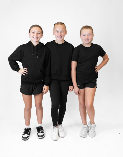 group of 3 girls with 2 wearing girls black flowy performance short with "LUKE 18:1" text