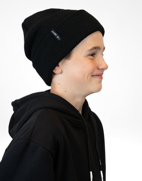 side view of person wearing black beanie with "LUKE 18:1" text