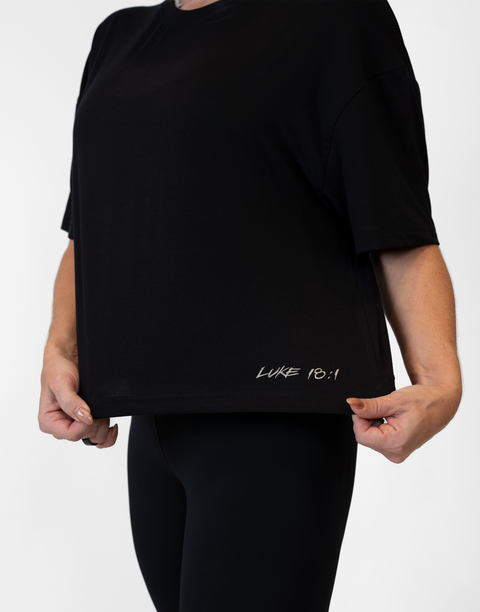 Woman wearing ladies Bamboo Mid-Crop Tee with "Luke 18:1" text above bottom seam