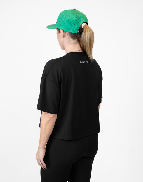 Rear view of woman wearing ladies Bamboo Mid-Crop Tee with "Luke 18:1" text on upper back