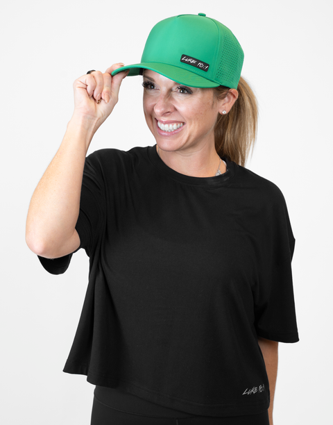 Woman wearing kelly green hat with "LUKE 18:1" text