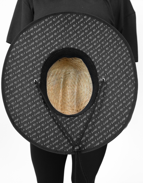 bottom view of straw hat showing "LUKE 18:1" text pattern under brim