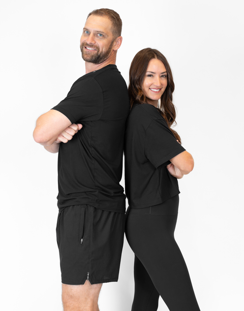 man and woman standing together with woman wearing ladies Bamboo Mid-Crop Tee with "Luke 18:1" text above bottom seam