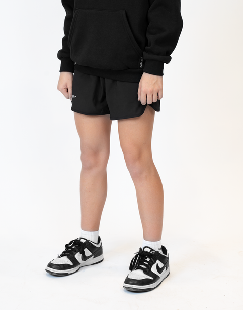 Girl wearing girls black flowy performance short with "LUKE 18:1" text