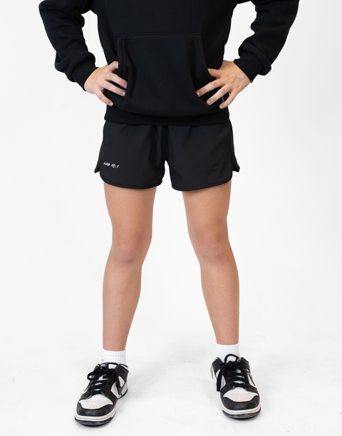 Girl wearing girls black flowy performance short with "LUKE 18:1" text