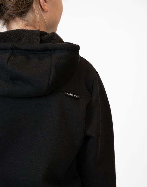 Rear view of Girl wearing Youth Black Fleece Hoodie showing "LUKE 18:1" text on upper right back