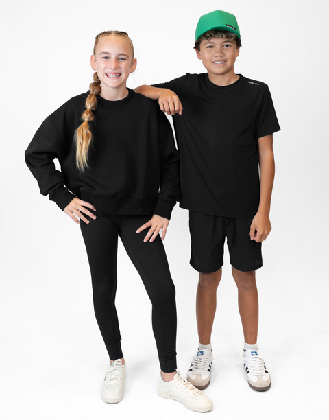 two people with one wearing Youth black Bamboo Performance Tee with "LUKE 18:1" text on shoulder