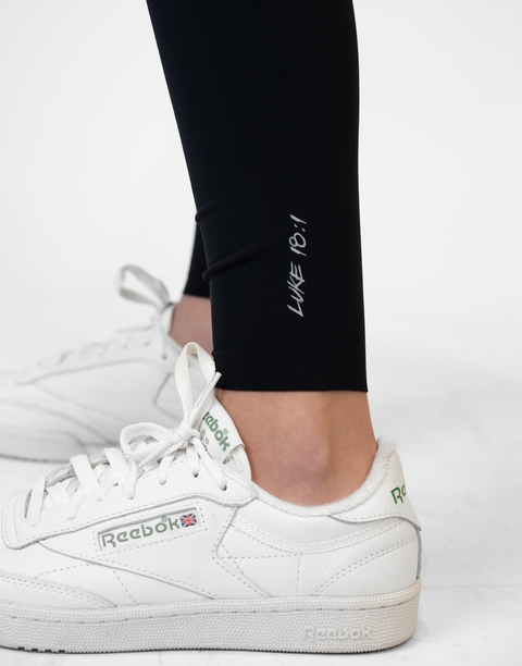 closeup of black Ladies Performance Legging with "LUKE 18:1" text on ankle