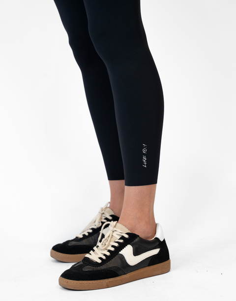 closeup of black Ladies Performance Legging with "LUKE 18:1" text on ankle