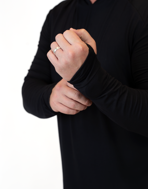 Closeup of man wearing Men's Black Bamboo Performance Hoodie showing thumb holes