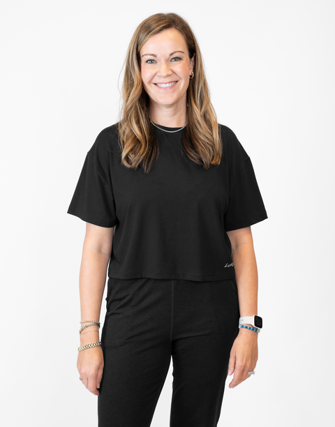 Woman wearing ladies Bamboo Mid-Crop Tee with "Luke 18:1" text above lower seam