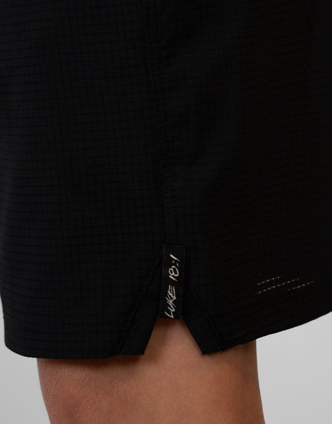 Boy wearing Youth Black Airflow Shorts showing "LUKE 18:1" text on side seam