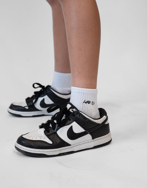 person wearing white socks with Luke 18:1 text in black